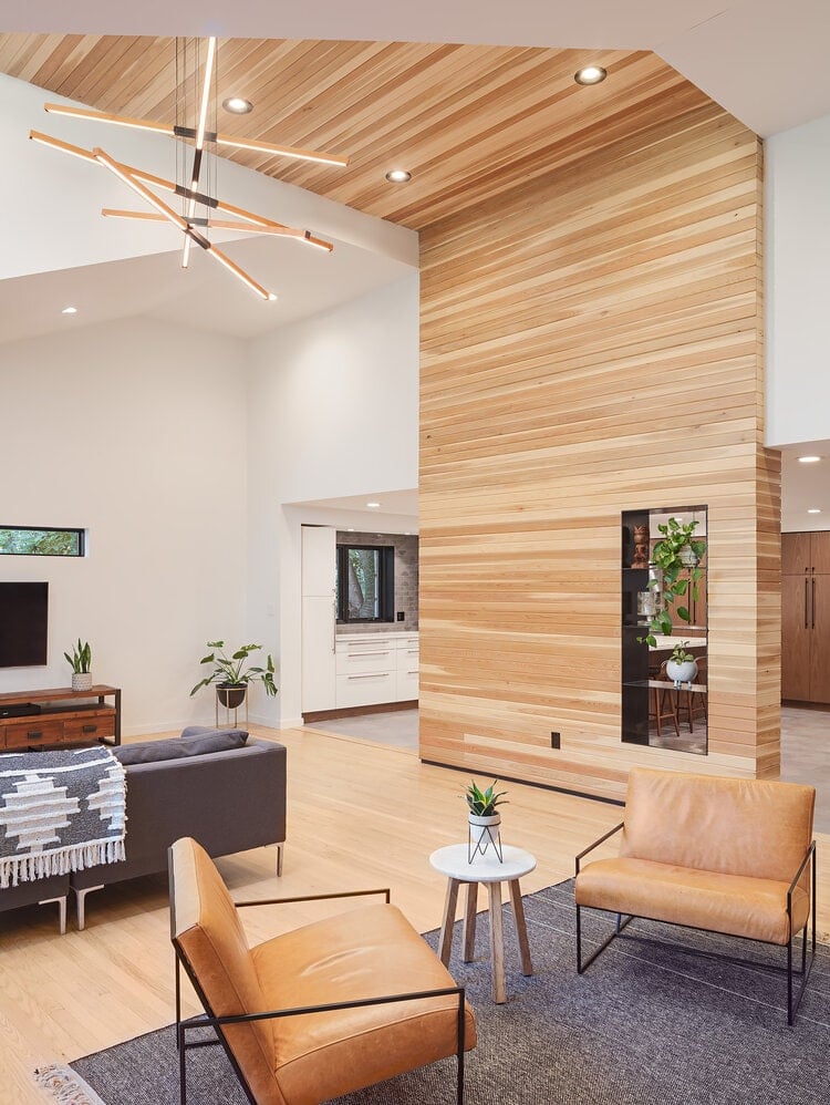The living room is separated from the kitchen by cedar that extends to the ceiling and is hung with orbital lighting.