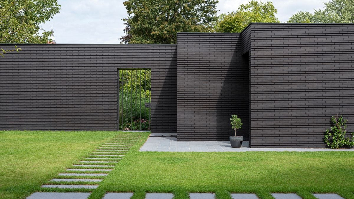 The facades are all-black brick, which both conceals and reveals the surroundings.