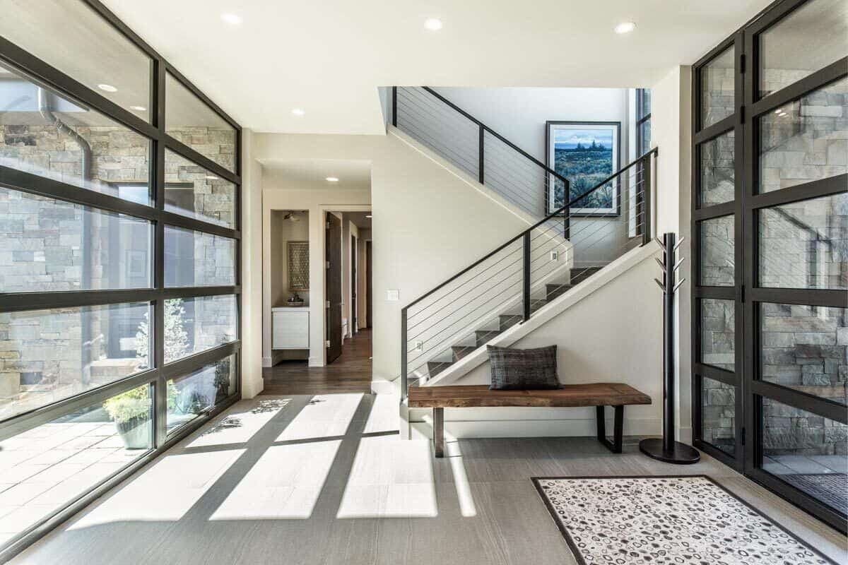 Floor-to-ceiling windows on either side bathe the foyer with an abundance of natural light.