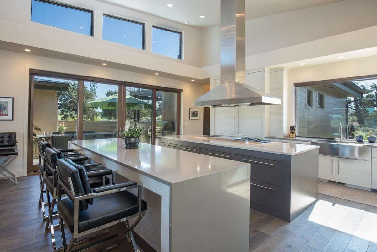 The kitchen is equipped with two islands, a built-in cooktop, and a farmhouse sink.