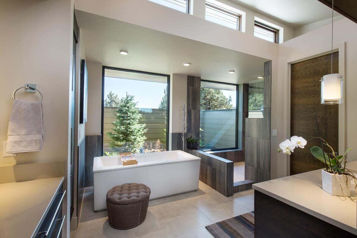 This bathroom features a walk-in shower and a deep soaking tub that looks out the private garden.