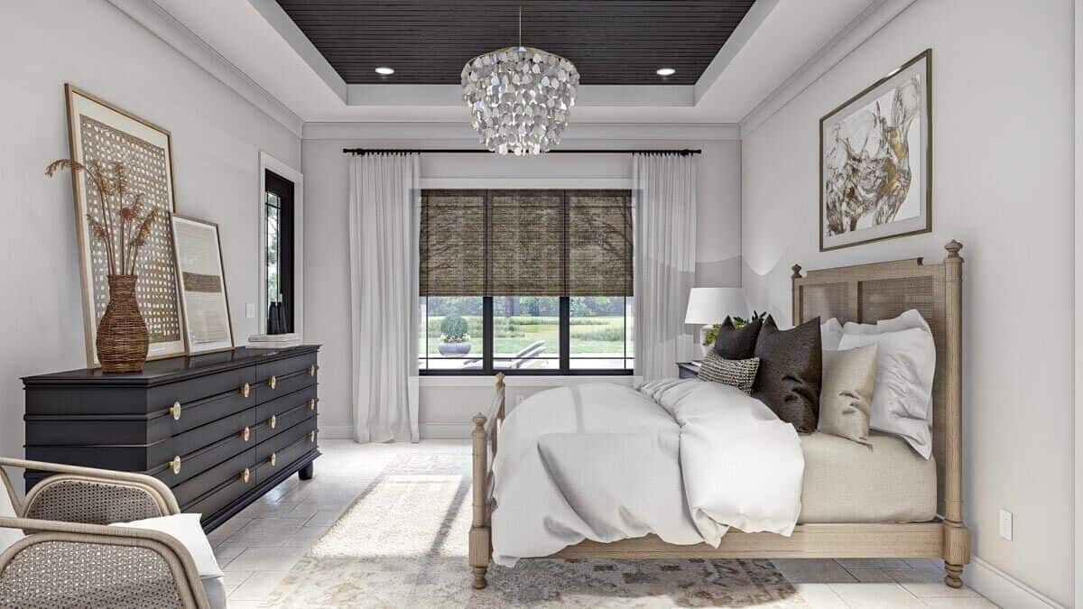 The primary bedroom features a tray ceiling, a wooden bed, and a black dresser.
