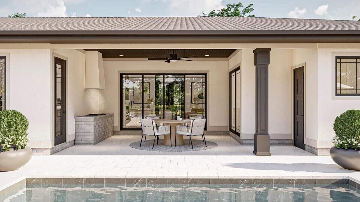 The covered lanai has a built-in grill and a round dining set.