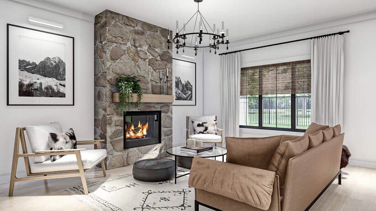 The great room has cushioned seats, a round coffee table, and a stone fireplace.