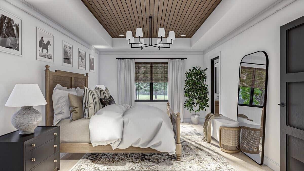 The primary bedroom has wooden furnishings and large windows that look out the backyard.
