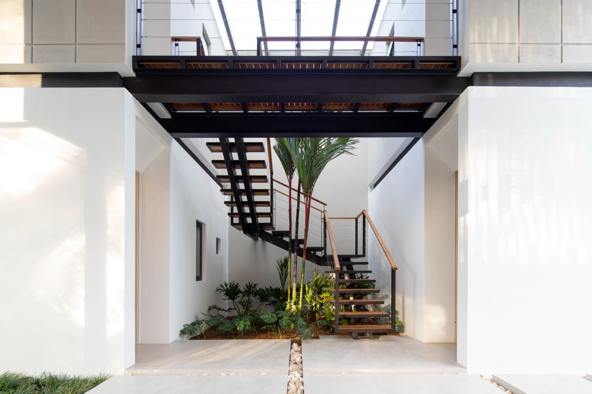 A steel stairs connect the open living space and the private area on the second floor.