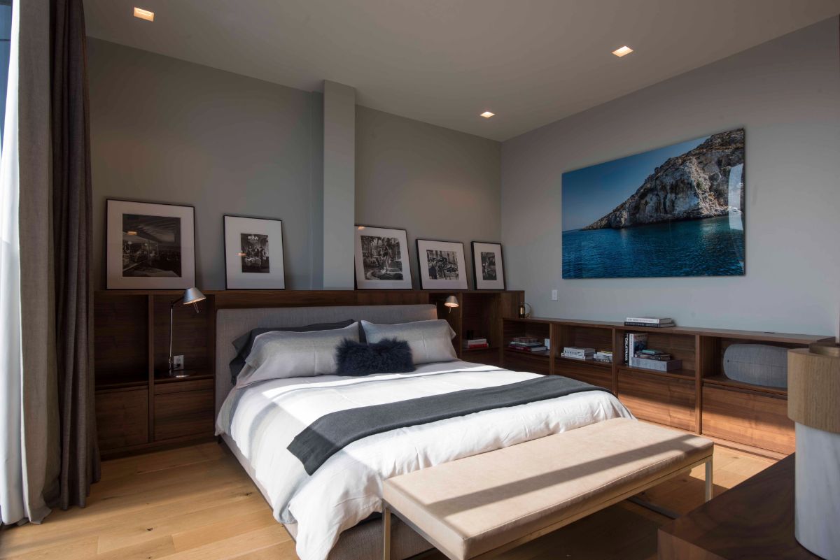 The bedroom has European oak flooring and gray walls, and photographs are also displayed.