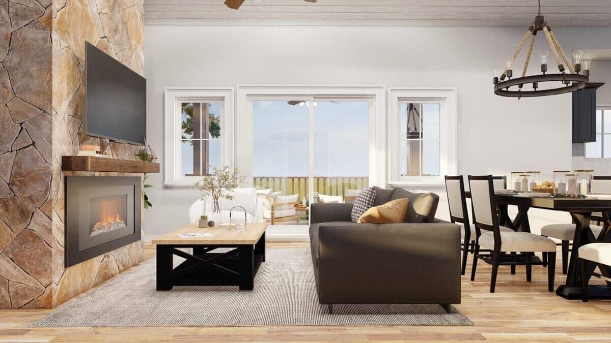 A stone fireplace with a TV on top sets an elegant focal point in the open living space.
