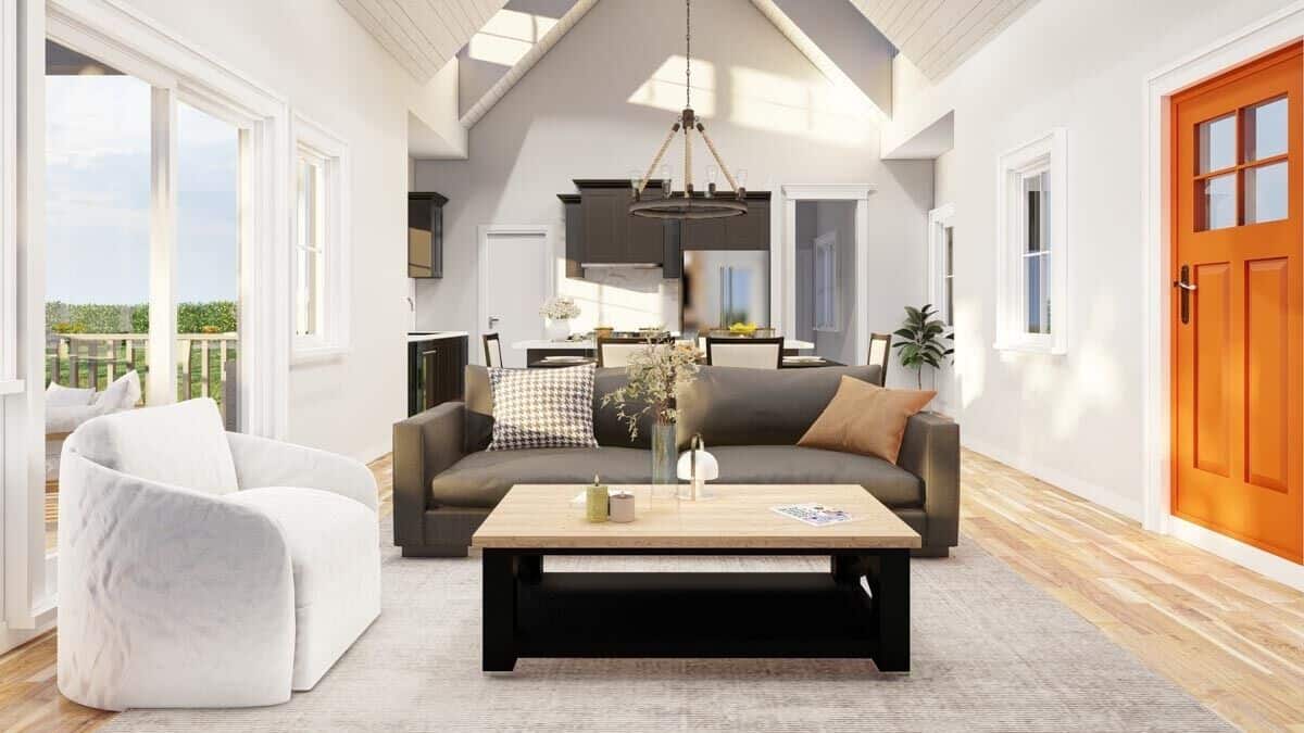 The great room has modern seats, a wooden coffee table, and sliding glass doors that open onto a covered porch.