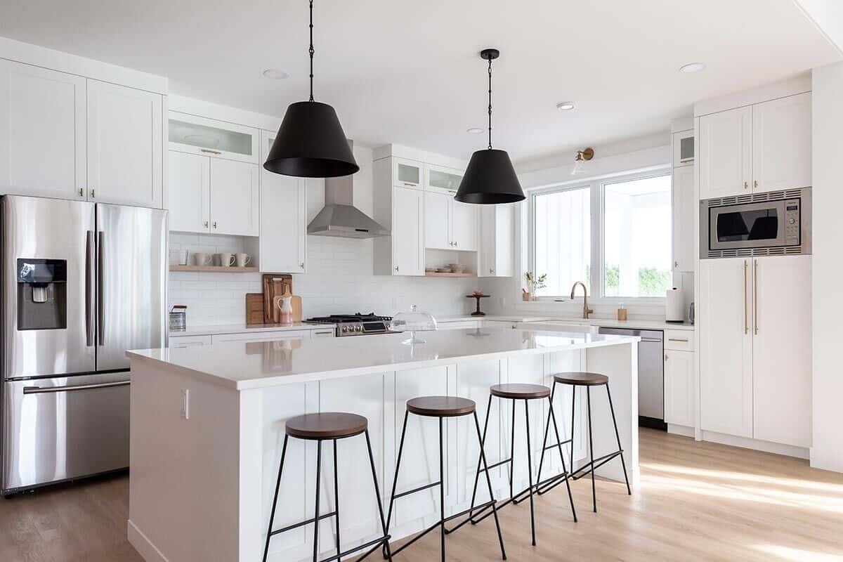 Round bar stools and black dome pendants complement the kitchen island.