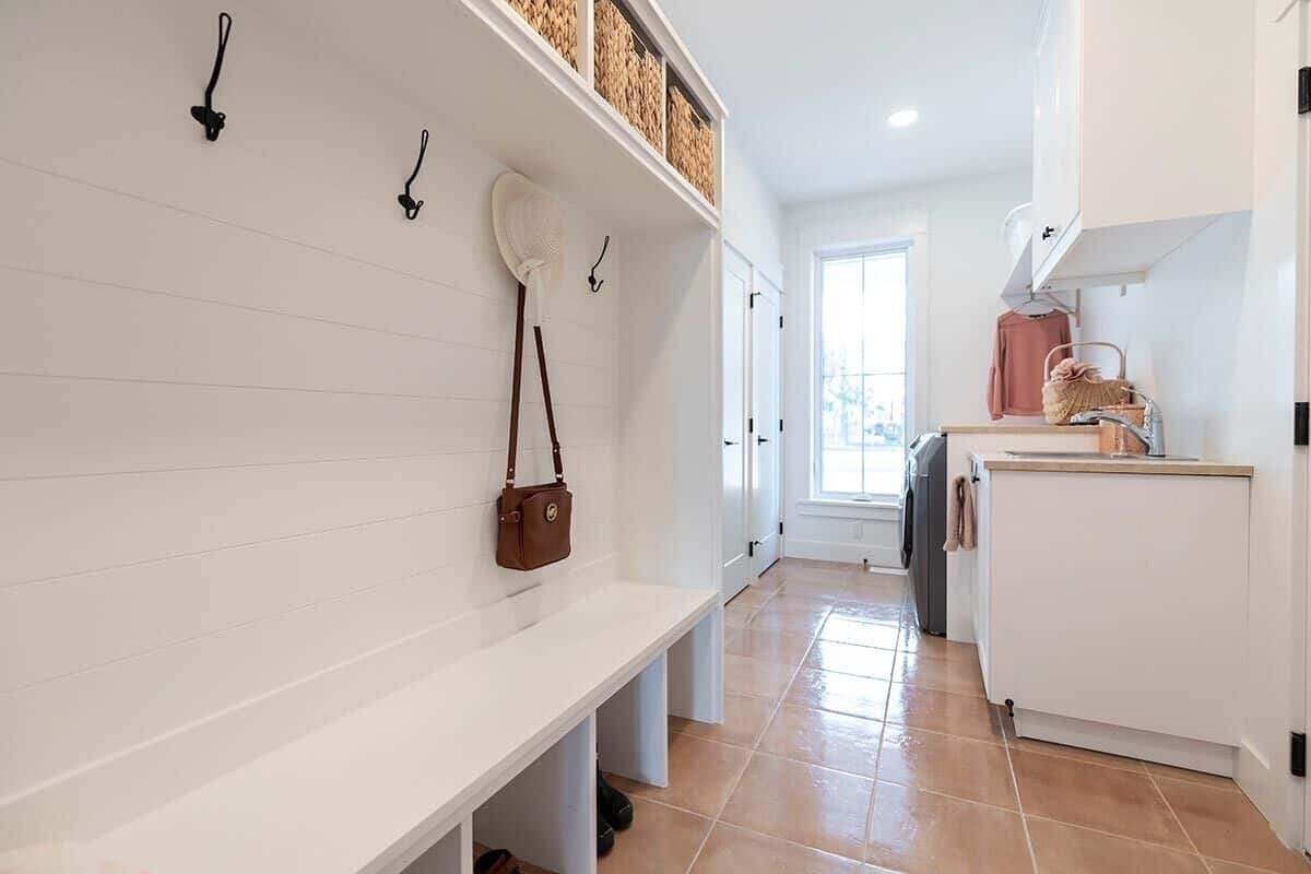 A built-in bench integrated with coat hooks and storage shelves completes the mudroom.
