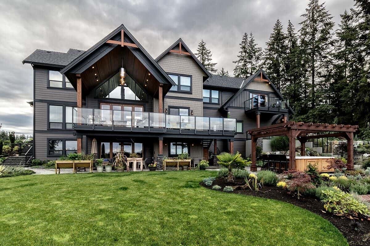 View of the house from the backyard showcasing expansive decks and a trellis porch.