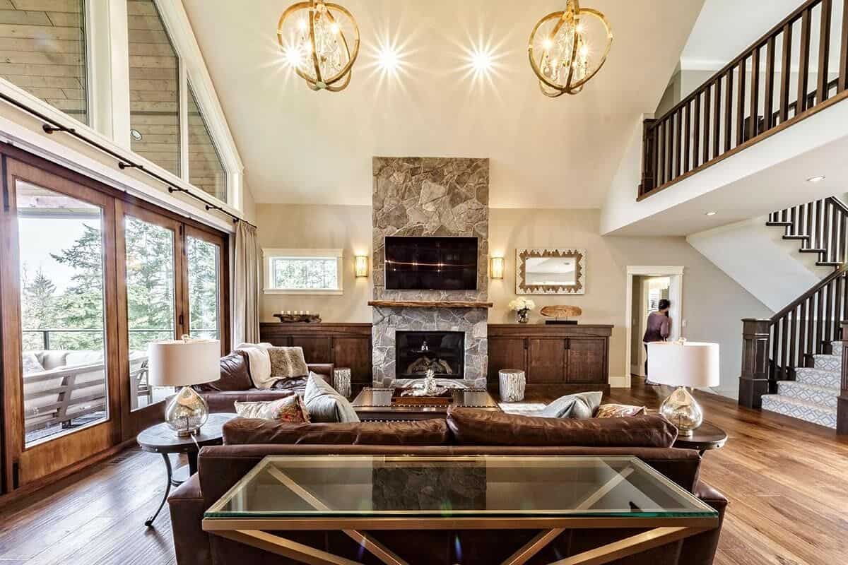 The great room includes a stone fireplace flanked by wooden cabinets.