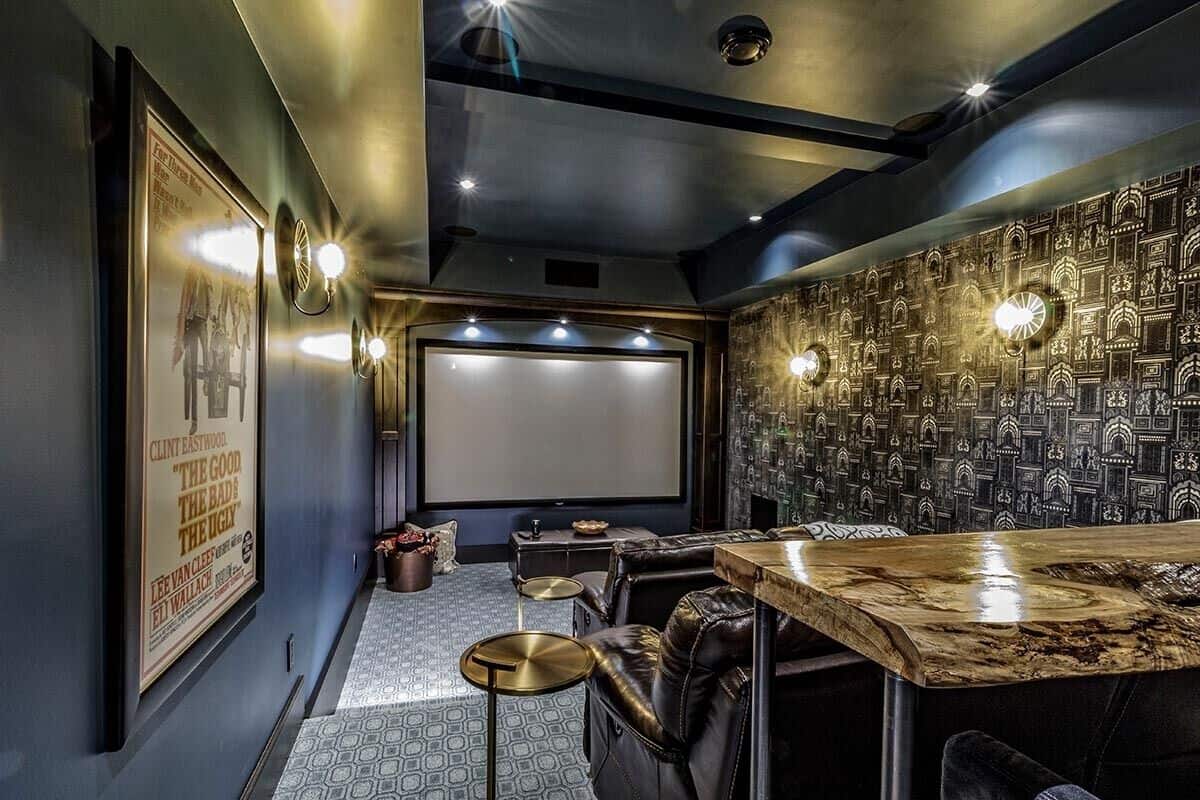 Home theater with dark walls, carpeted floor, leather seats, and a bar.