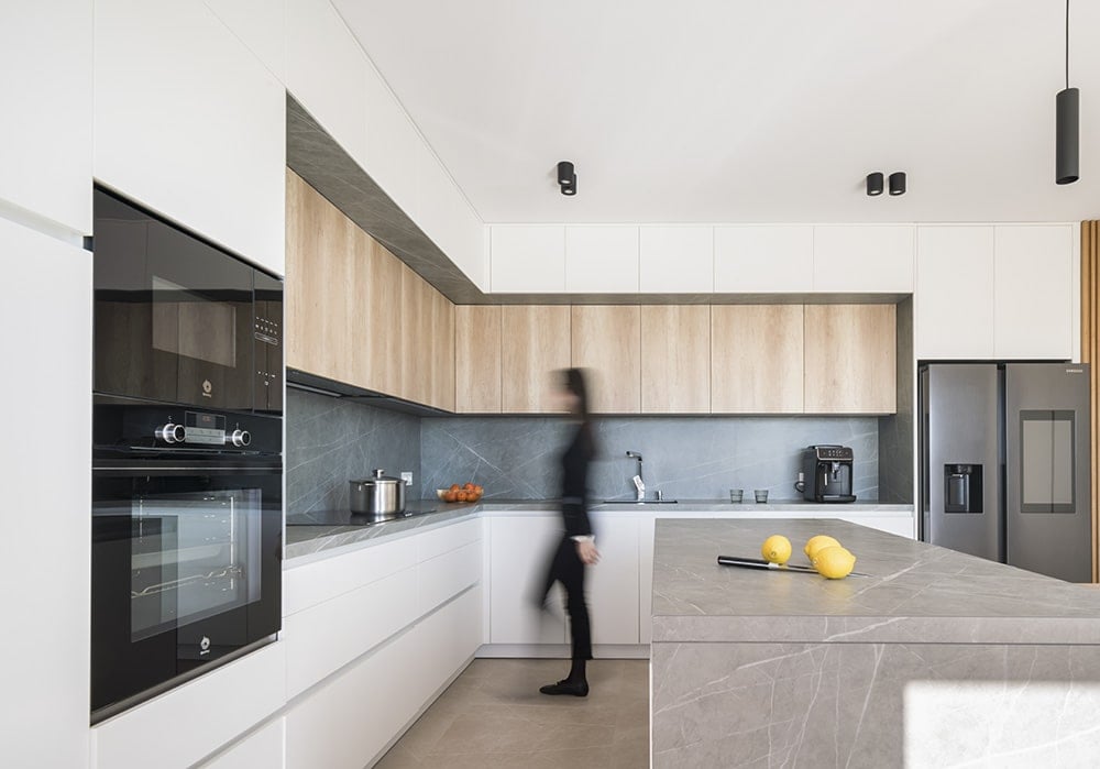 Contrasting cabinets, top-of-the-line appliances, and marble backsplash complete the kitchen.