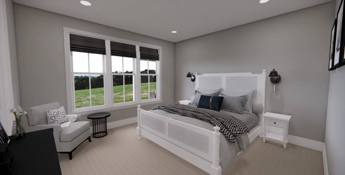 Primary bedroom with a white bed and a cushioned armchair over the carpeted floor.