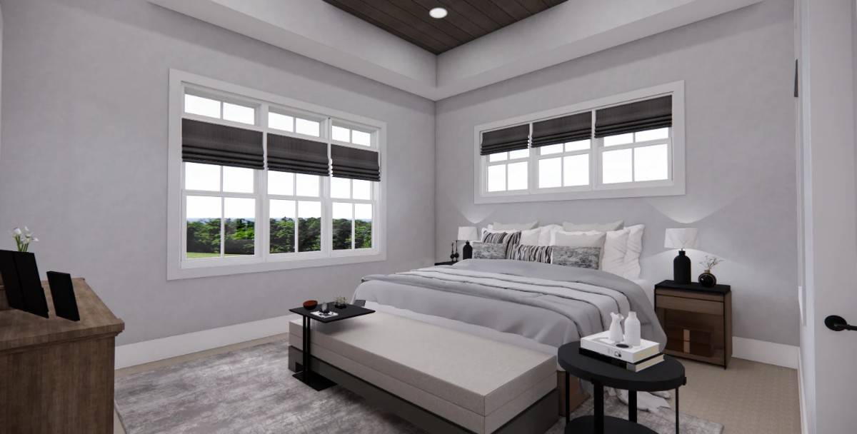 The primary bedroom features a tray ceiling and a large bed complemented with a cushioned bench.