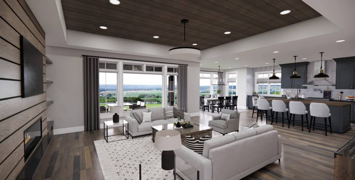 An open layout view of the great room, kitchen, and dining area surrounded by large windows.
