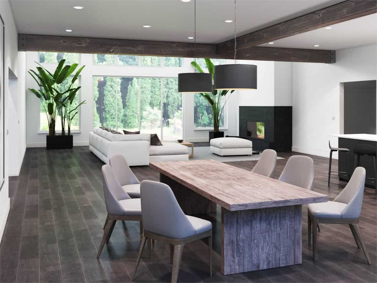 The dining area has upholstered chairs and a rustic dining table topped with a couple of drum pendants.