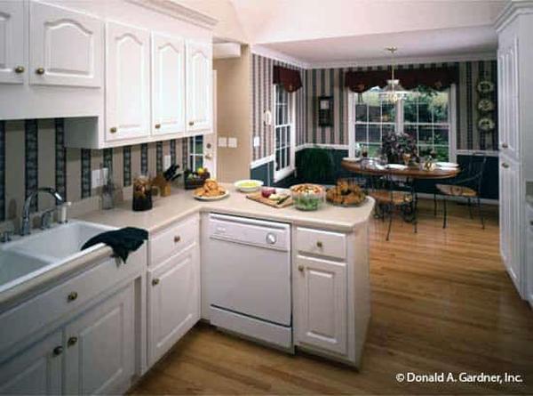 The kitchen is equipped with white appliances, custom cabinetry, and a double bowl sink paired with a gooseneck faucet.