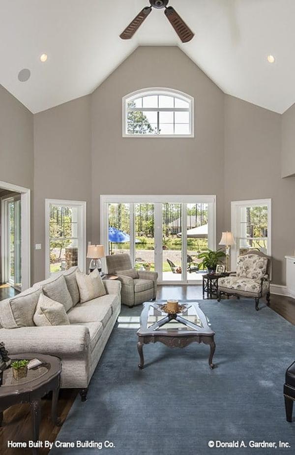 Living room with upholstered seats, a glass top coffee table, and a french door that leads out to the back porch.