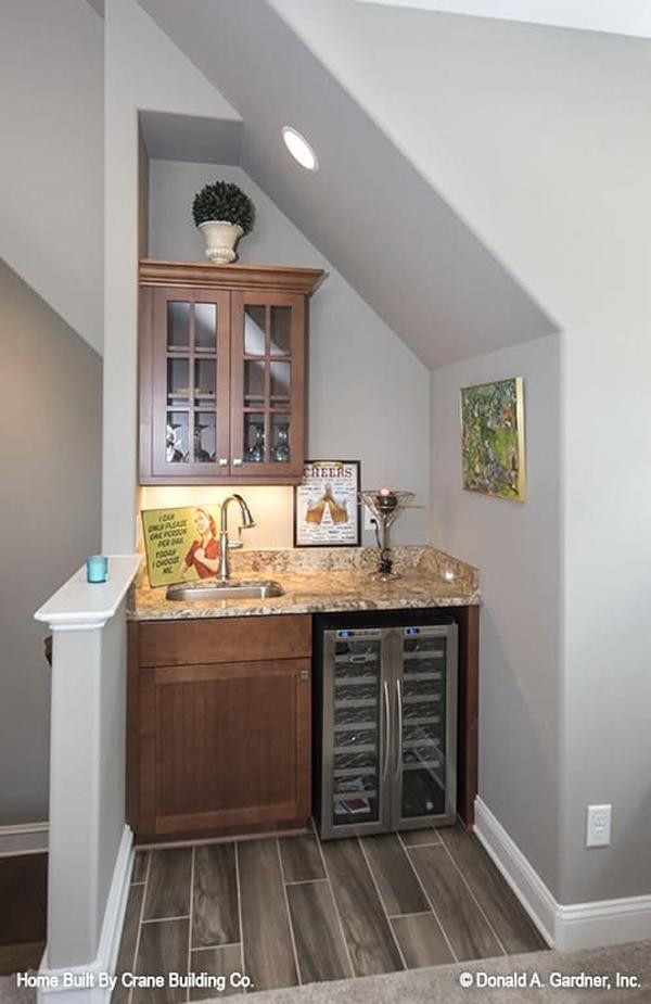A wet bar with a granite countertop and a beverage fridge complete the bonus room.