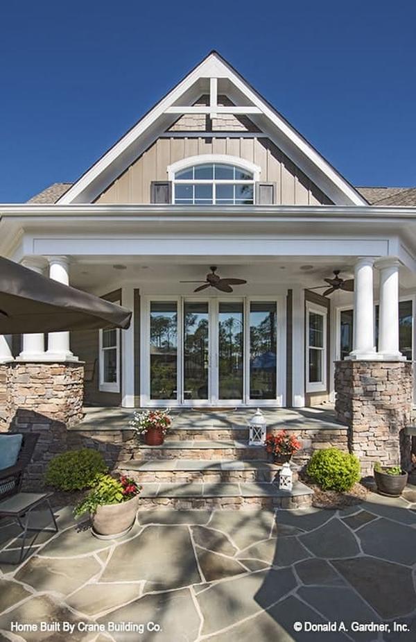 The covered porch is graced by double columns and a large gable adorned with white trims and a transom window.