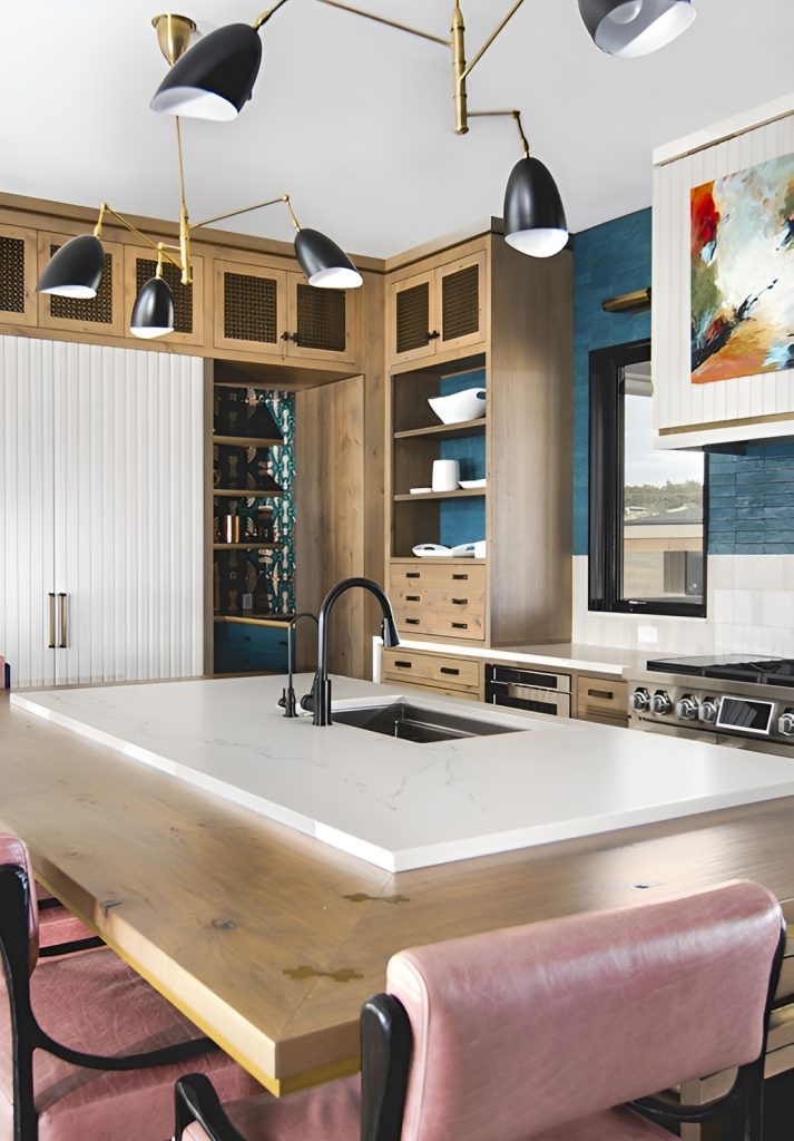 The kitchen features a large island with marble and wood countertops along with an undermount sink.