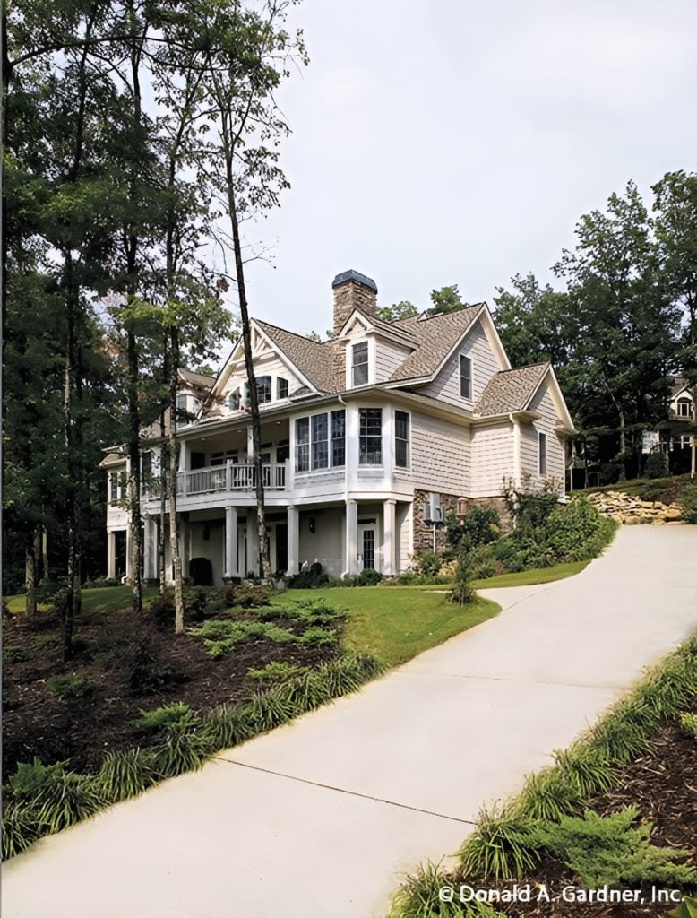 Rear exterior view showing the shed dormers and covered porches framed with white pillars.