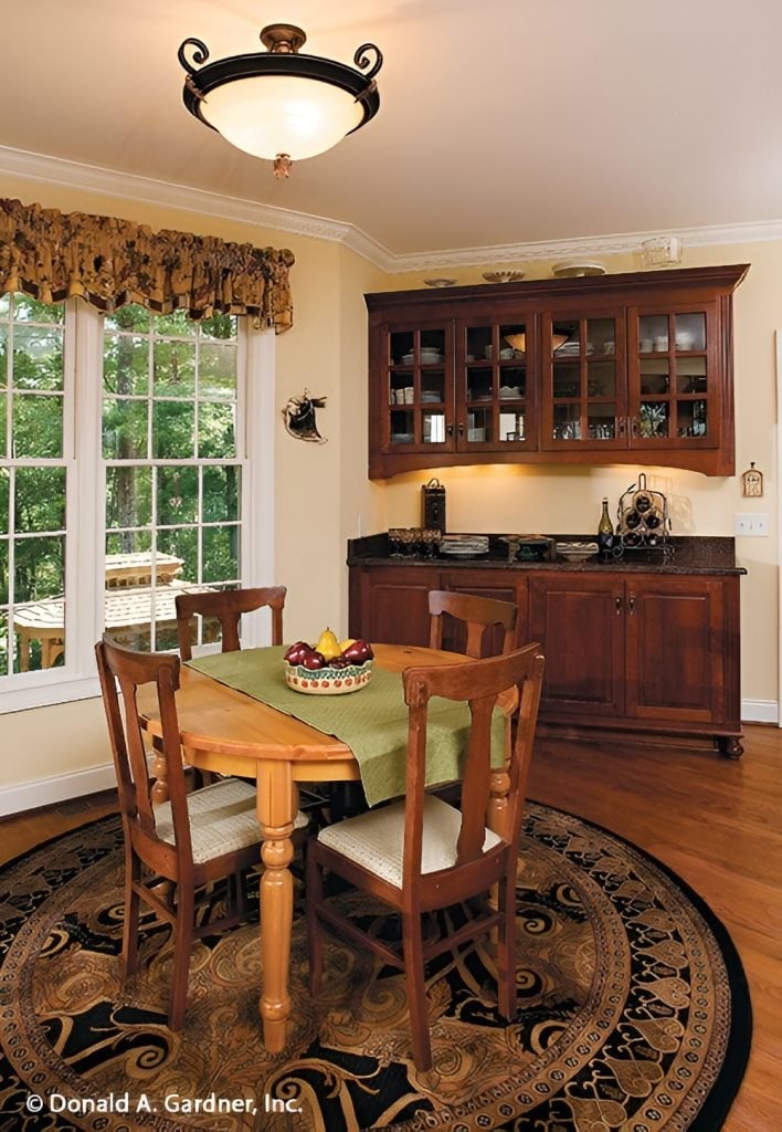 Breakfast area with a buffet cabinet and a round dining set sitting on a patterned area rug.