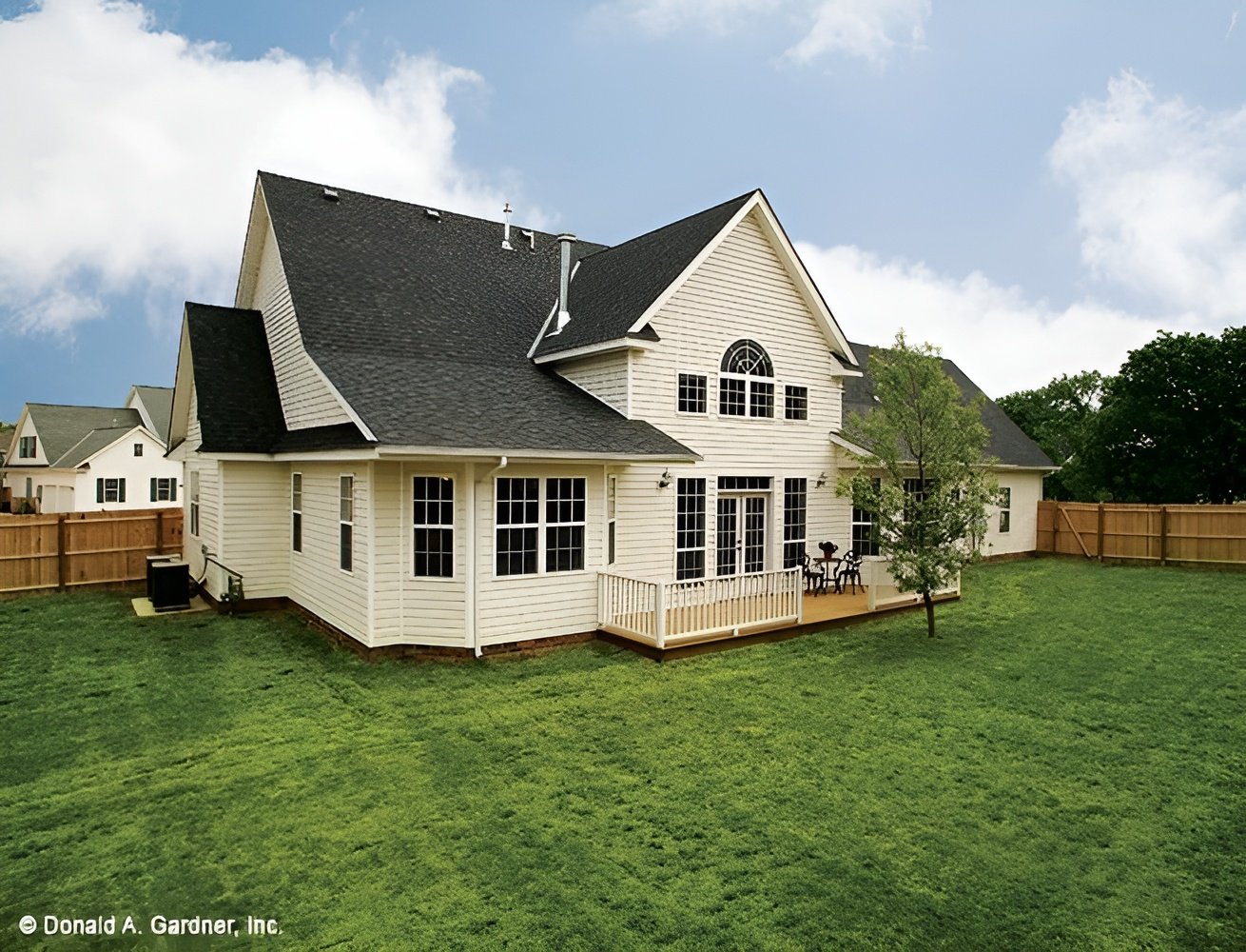 Rear exterior view with a spacious deck bordered by white railings.