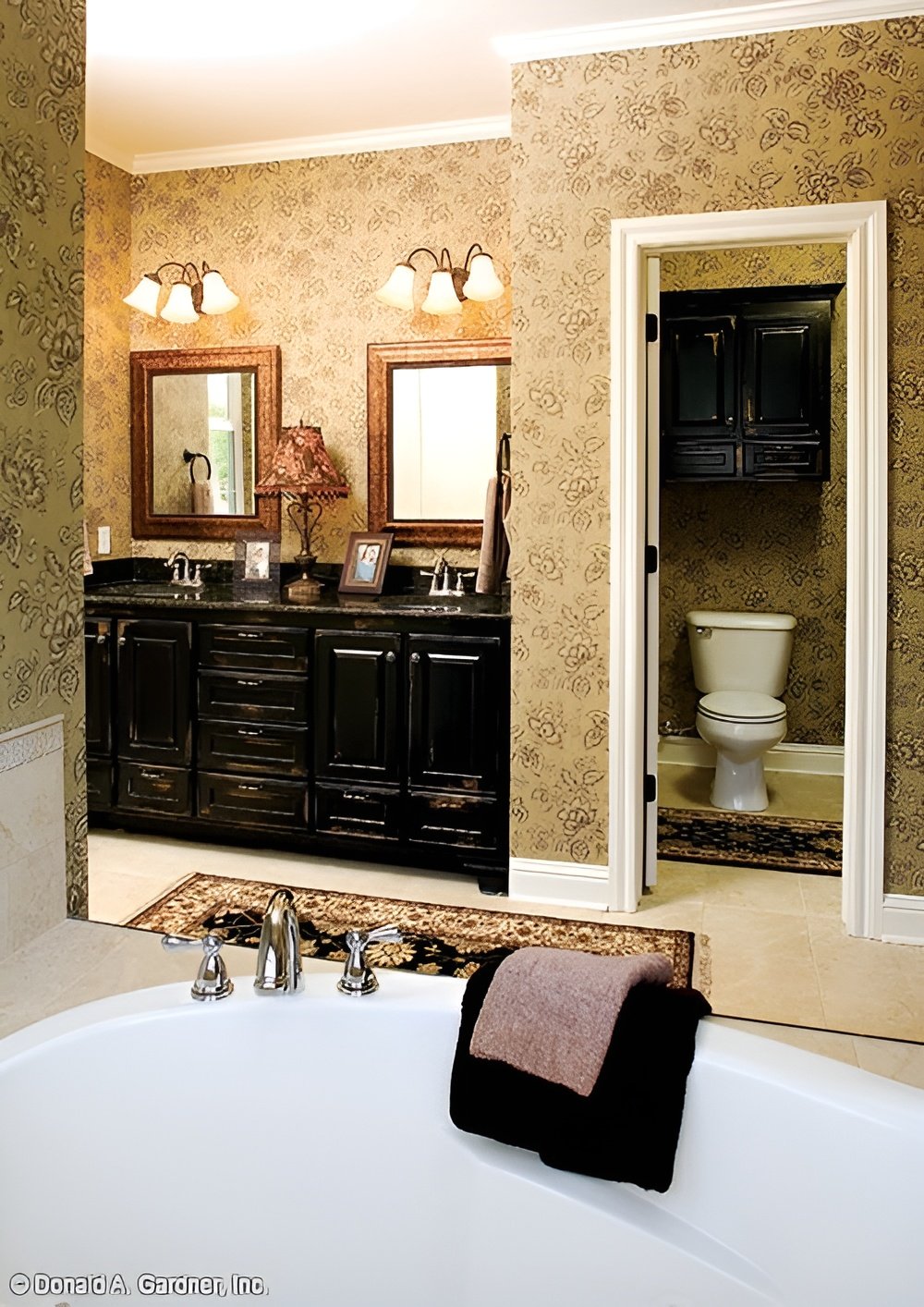 Primary bathroom with a dual sink vanity, a deep soaking tub, and a toilet room.
