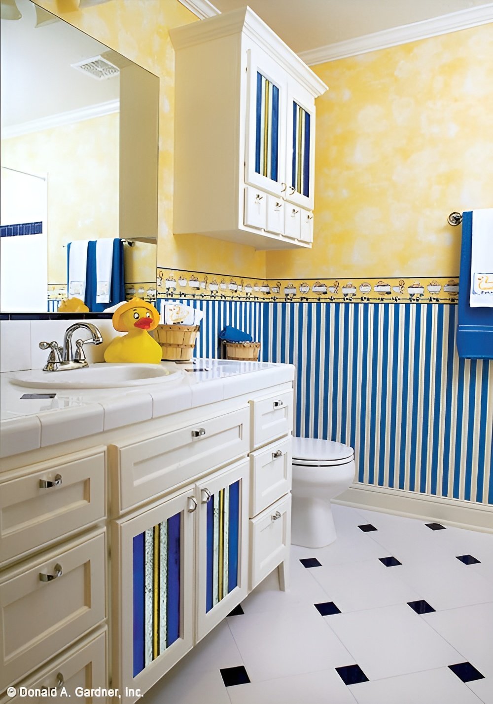 This bathroom is equipped with single sink vanity and a toilet topped with an overhead cabinet.