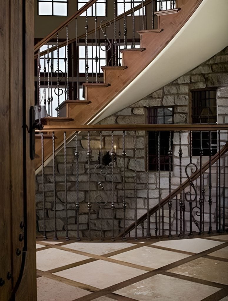 A closeup view of the elaborate balcony and staircase framed with ornate wrought iron railings.