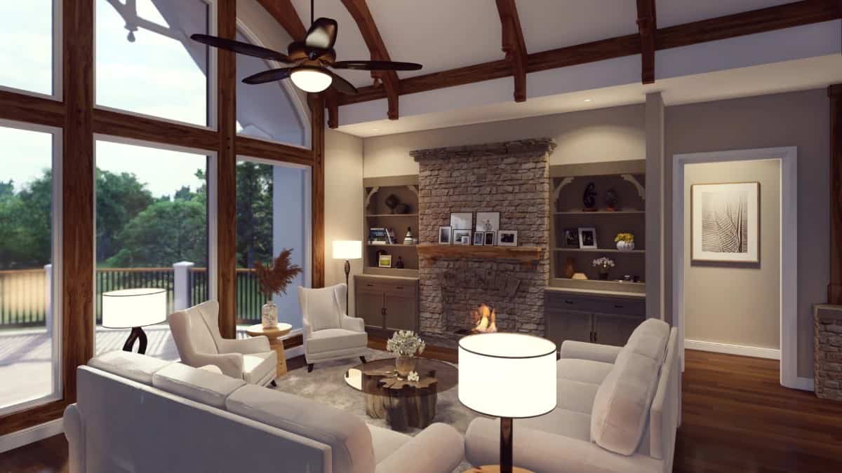 The lodge room features a stone fireplace, a vaulted ceiling, and a wall of windows that looks out the rear deck.