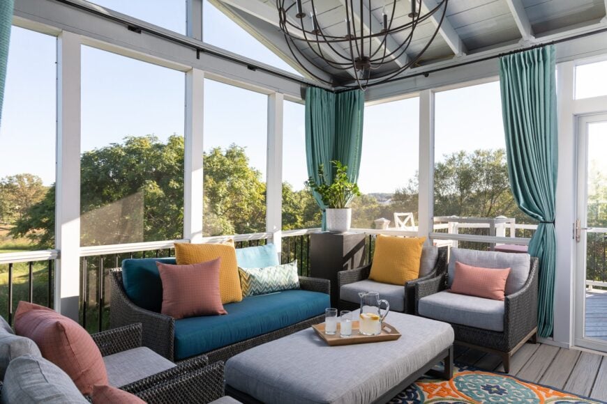 This screened-in porch is a tranquil oasis, covered by window screens while offering a breathtaking view of lush farm trees. The sofa lounge set that is crafted from woven materials exudes both comfort and natural elegance. It's a perfect space to relax, unwind, and embrace the beauty of the surrounding nature.