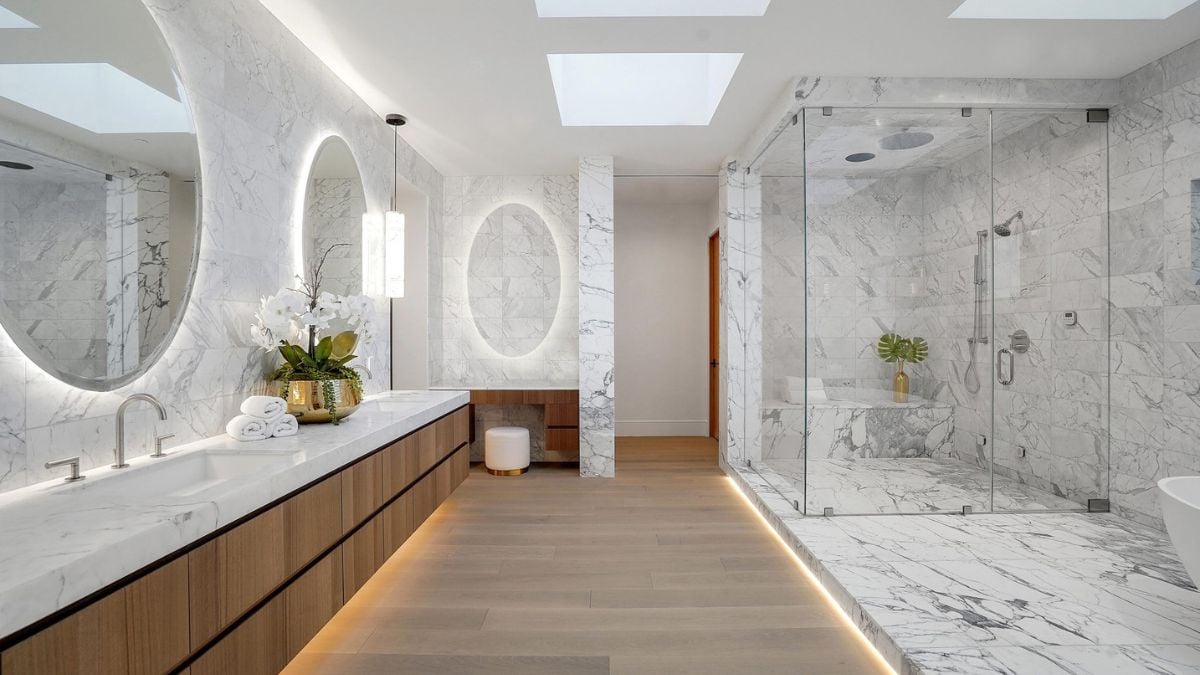 Step into the all-white marble bathroom with radiant flooring and a runway of light hardwood seamlessly extending from the bedroom.