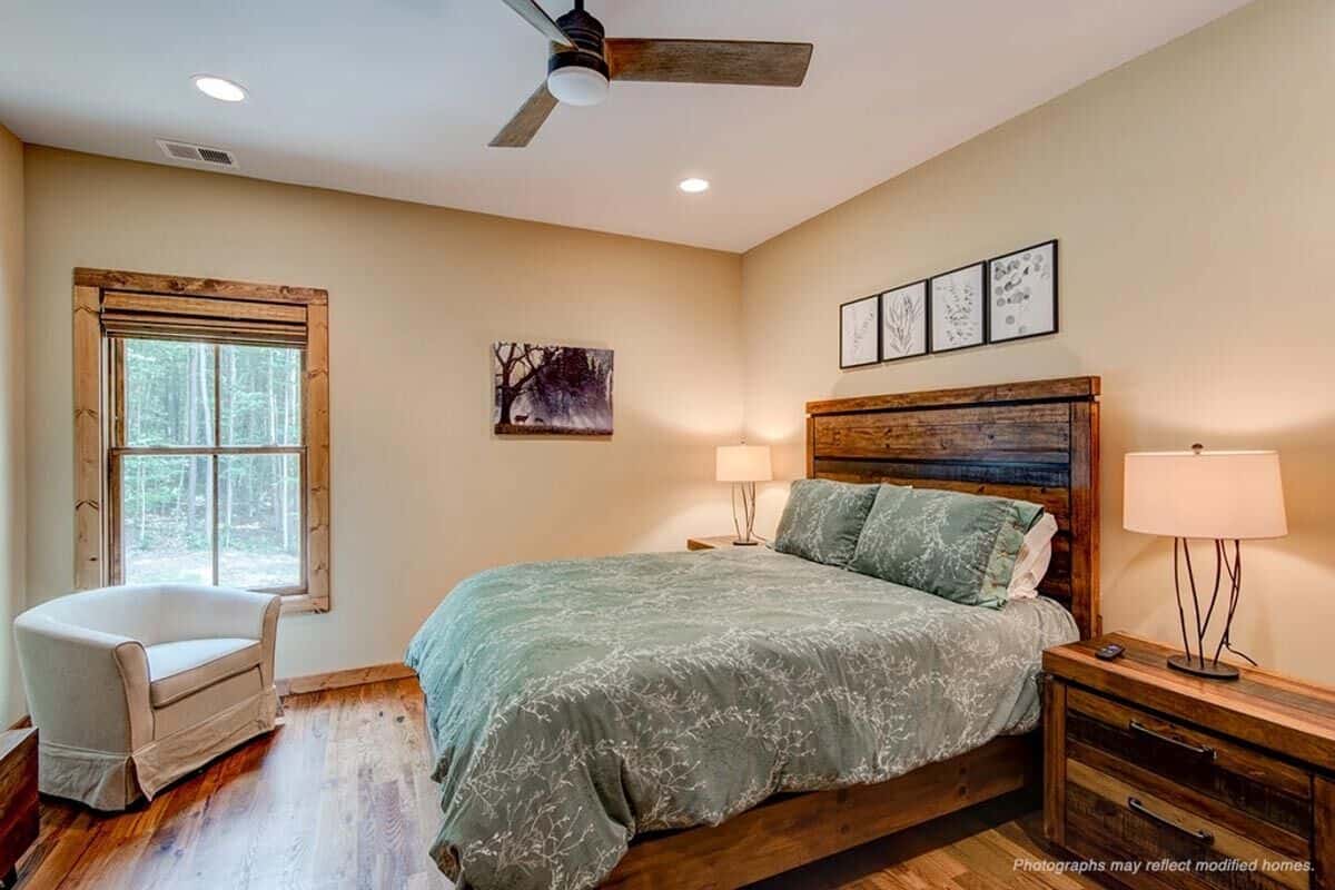 Second bedroom with a round-back chair and a wooden bed flanked by matching nightstands.