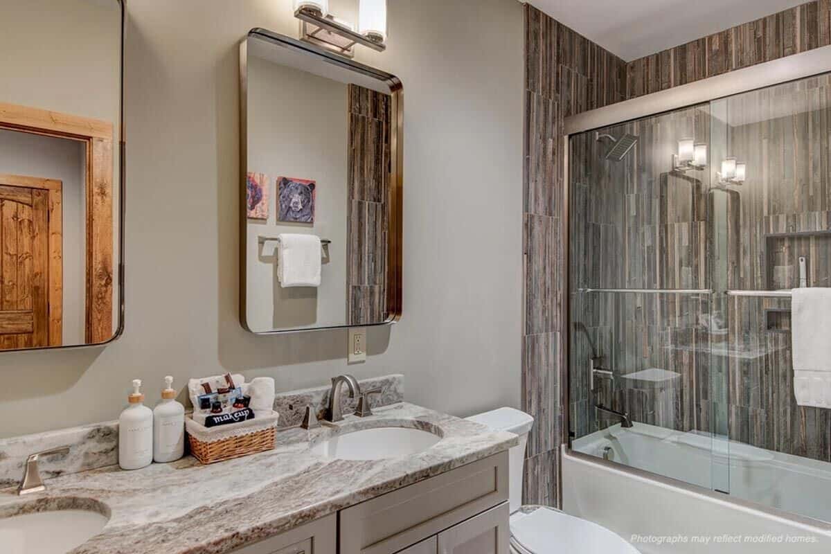 Shared bathroom with a dual sink vanity and a tub and shower combo.