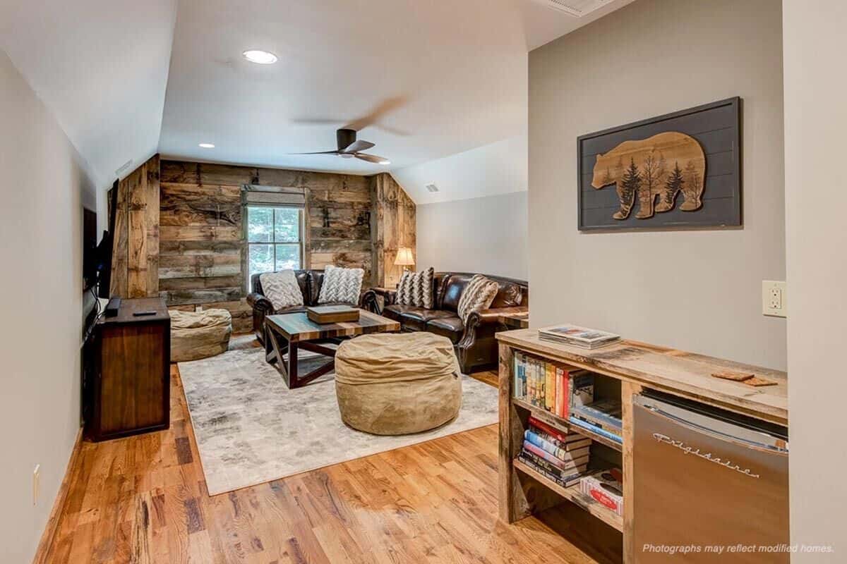 Bonus room with leather seats and wooden tables under a vaulted ceiling.