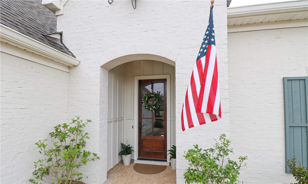A closer look at the arched entry with a glazed front door.