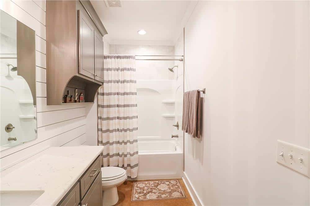 Shared bathroom with a sink vanity and a tub and shower combo.