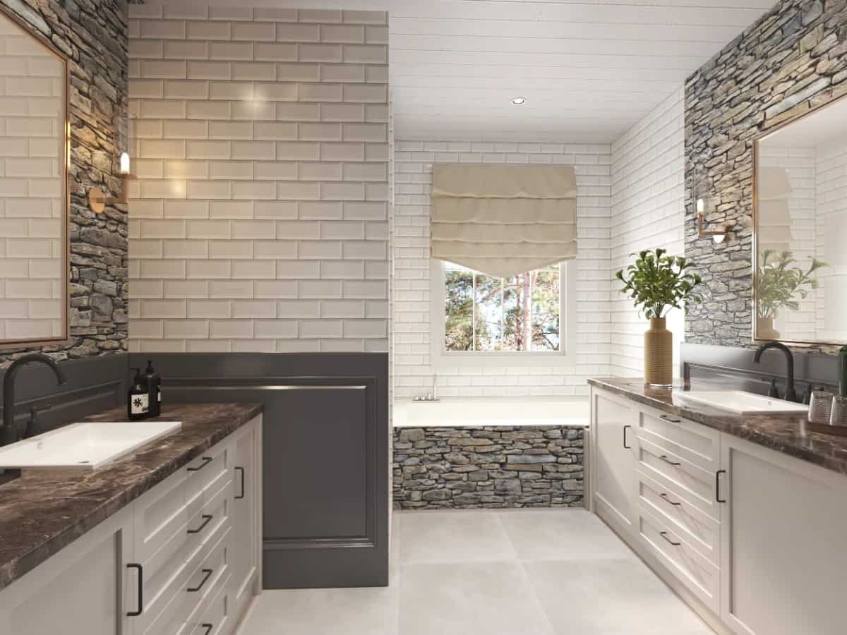 Deluxe primary bathroom with his and her sink vanities, and a deep soaking tub accentuated with stonework.