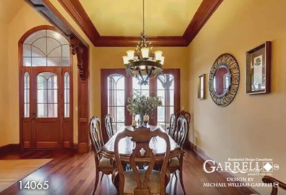Foyer and dining room with glazed doors, hardwood flooring, and yellow walls.