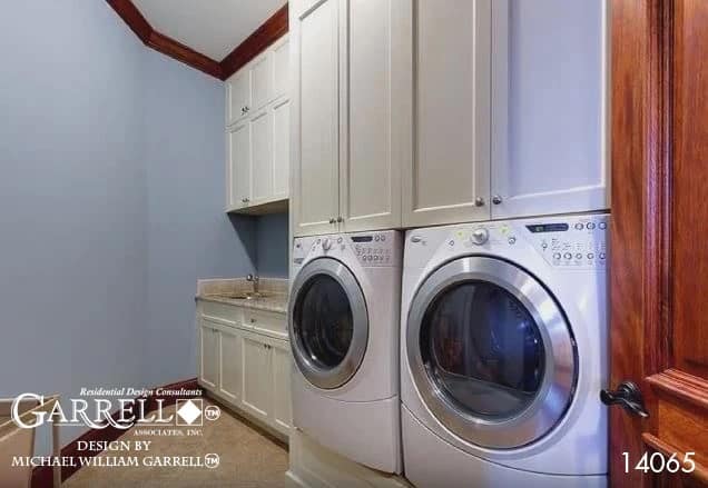 The laundry room offers ample storage, front-load appliances, and a sink.