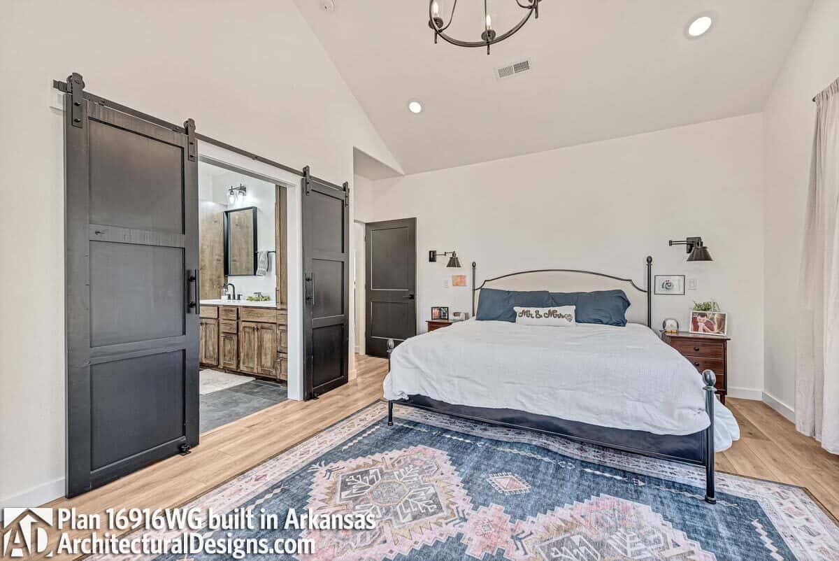 The primary bedroom includes an ensuite bathroom enclosed in double sliding barn doors.