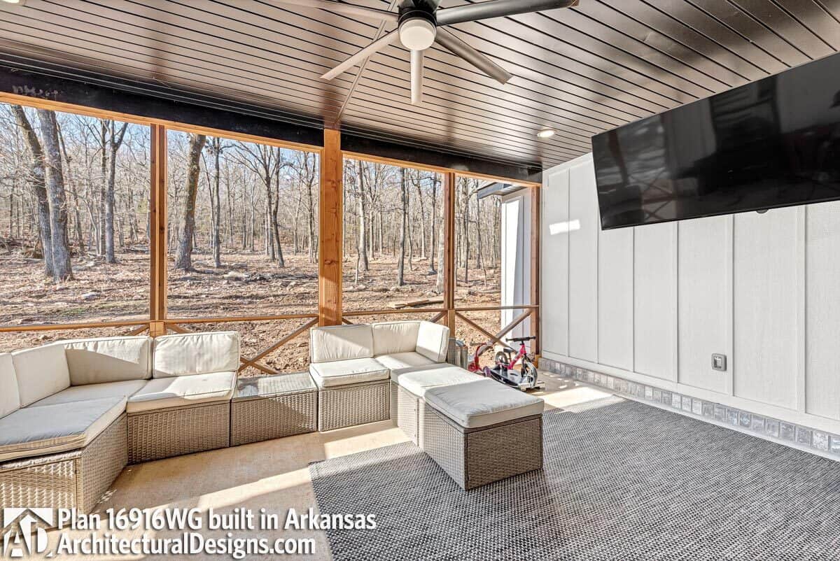 Covered lanai with wicker seats and a large TV.