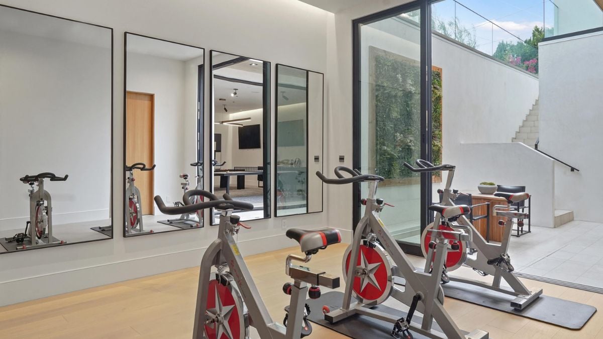 The Home Gym Fitness Center features a window wall of sliding glass doors that open directly to a shared patio.