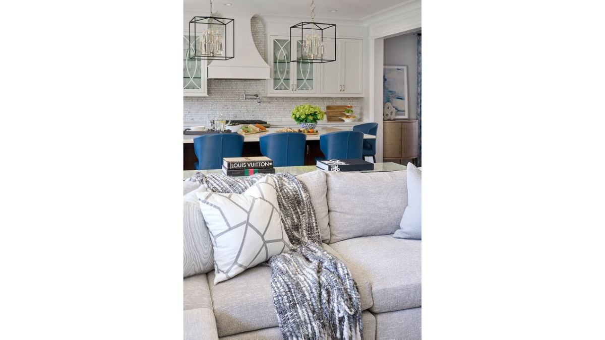 The island counter is located behind the couch, and it has a neutral color scheme.