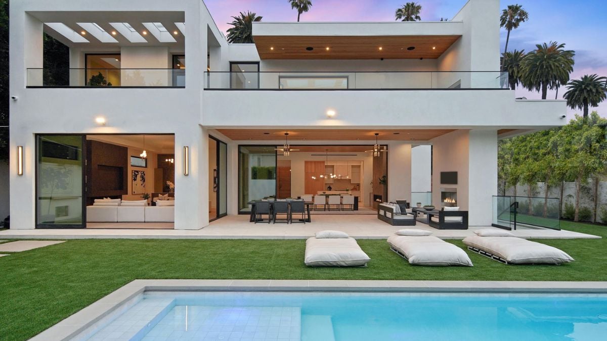 Experience the stunning rear section of the home, characterized by sleek lines, expansive windows, and thoughtfully landscaped surroundings.